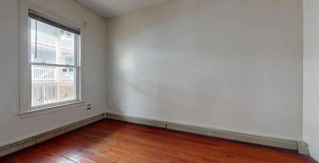 19 Newport Street, Unit 2 Boston, MA 02125 - Photo 5 of 13 an empty room with wooden floor and windows