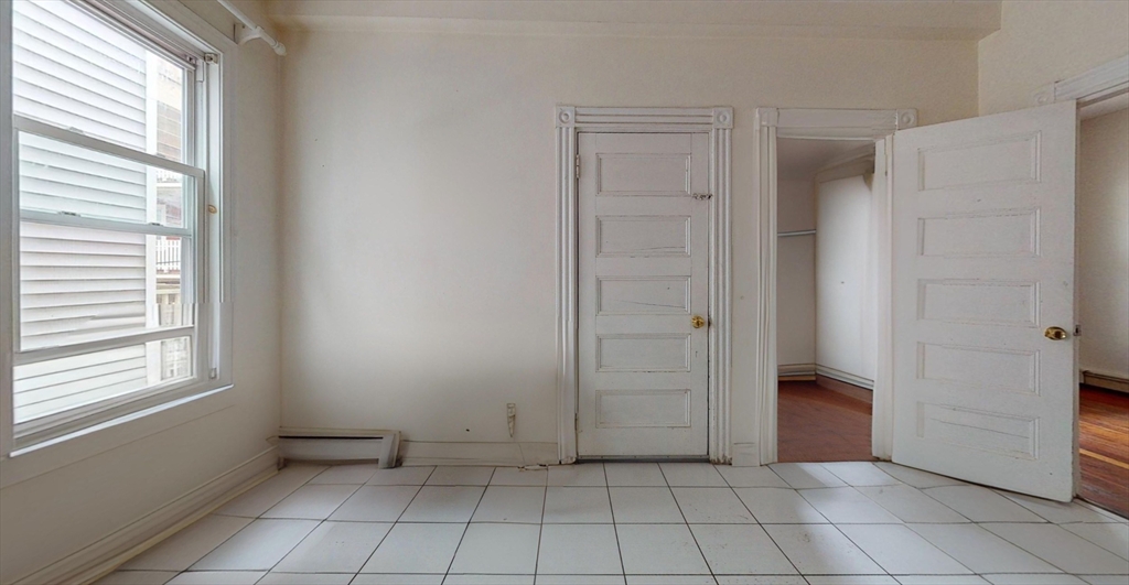 19 Newport Street, Unit 2 Boston, MA 02125 - Photo 6 of 13 a view of an empty room with window and chandelier fan