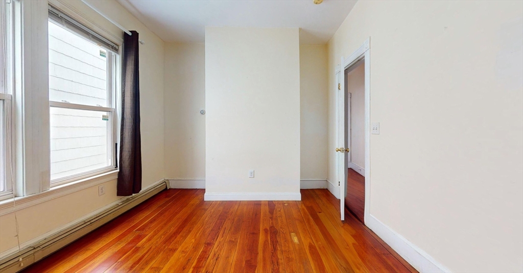 19 Newport Street, Unit 2 Boston, MA 02125 - Photo 8 of 13 an empty room with wooden floor and windows