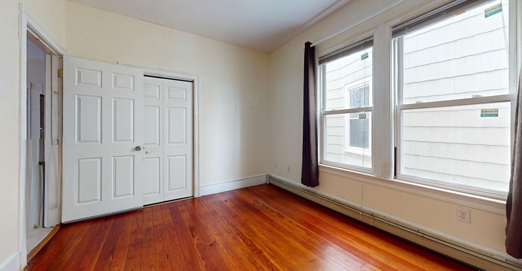 19 Newport Street, Unit 2 Boston, MA 02125 - Photo 9 of 13 a view of an empty room with wooden floor and a window