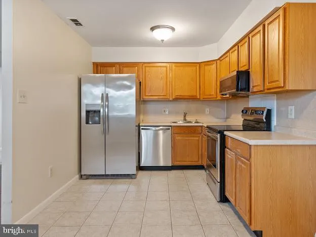 a kitchen with a sink refrigerator and cabinets