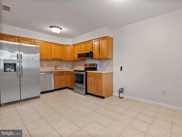 a kitchen with stainless steel appliances granite countertop a stove a sink and a refrigerator