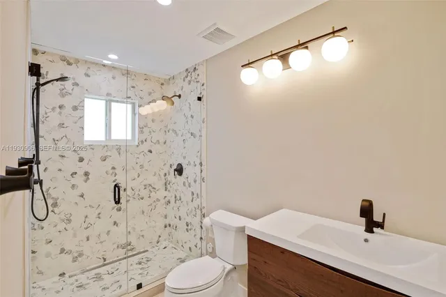 a bathroom with a sink a toilet and shower