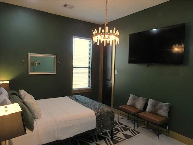 a bedroom with a bed and a chandelier