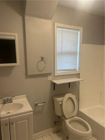 a bathroom with a toilet sink vanity and mirror