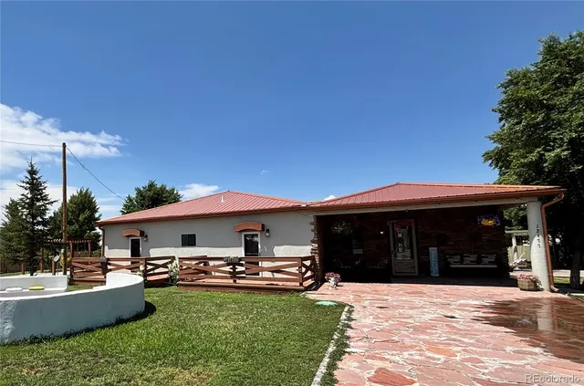 a front view of a house with swimming pool having outdoor seating