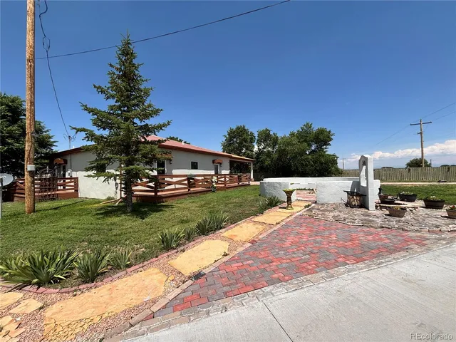 a view of a backyard with a garden and fire pit