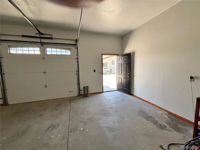 an empty room with windows and chandelier