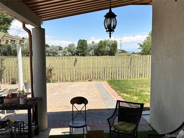 a view of a balcony with table and chairs and potted plants