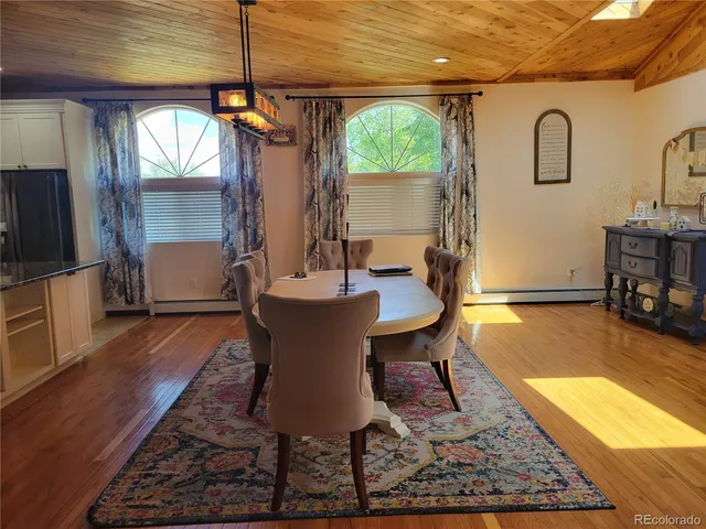 a dining room with wooden floor and a rug