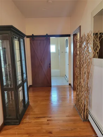 a view of a hallway with wooden floor and stairs
