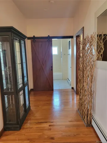 a view of a hallway with wooden floor and stairs