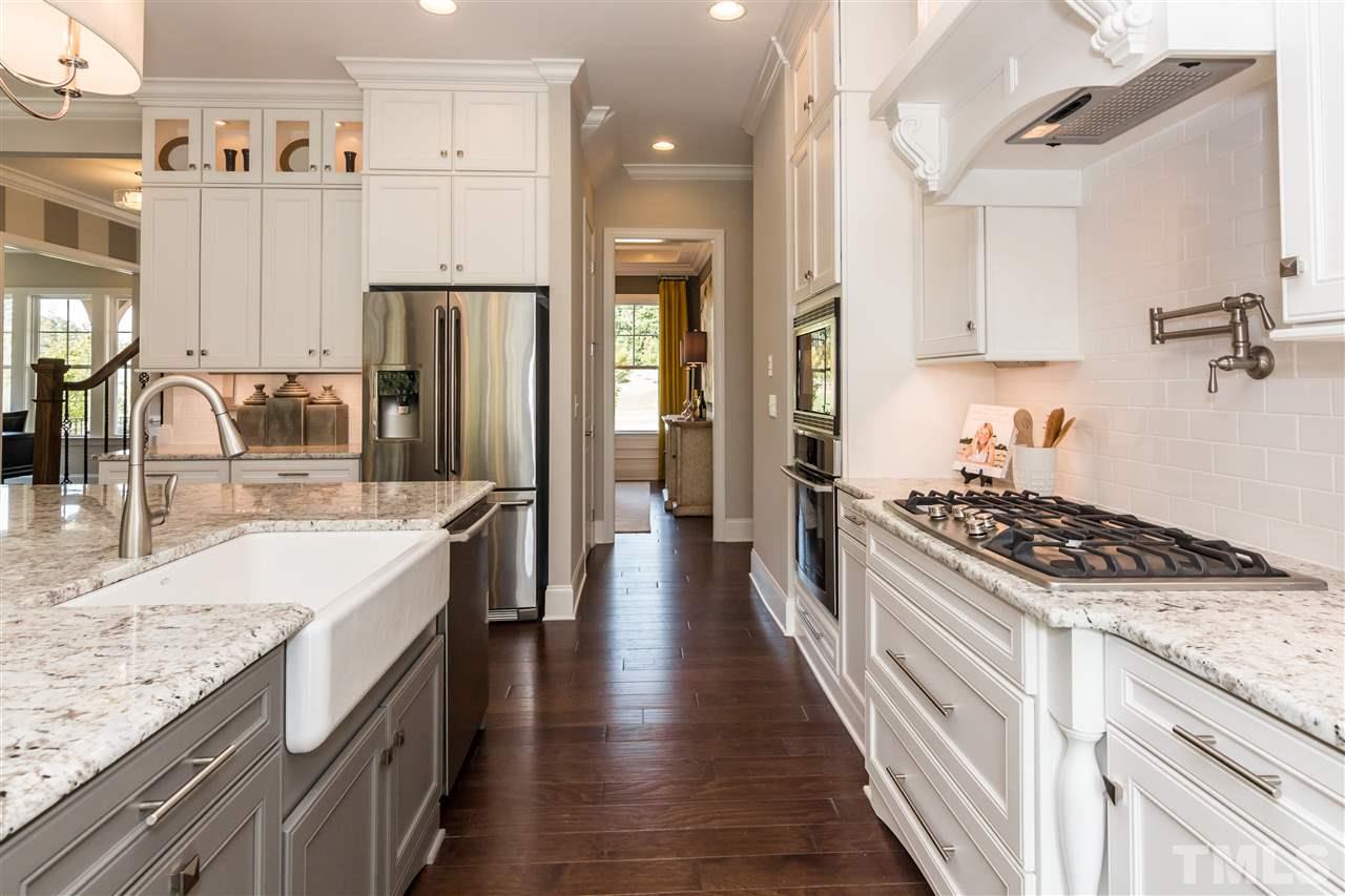 520 Belle Gate Place Cary, NC 27519 - Photo 13 of 25 a kitchen with stainless steel appliances granite countertop a sink stove and refrigerator