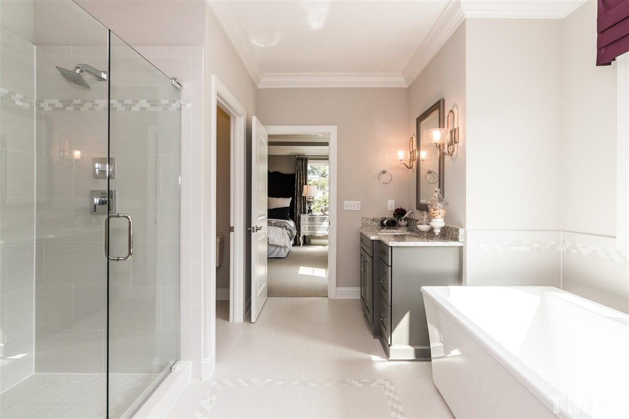 520 Belle Gate Place Cary, NC 27519 - Photo 21 of 25 a bathroom with a tub a sink a mirror and a shower