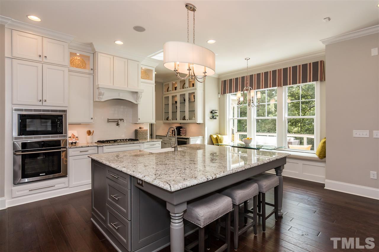 520 Belle Gate Place Cary, NC 27519 - Photo 11 of 25 a kitchen with granite countertop a stove a sink a microwave and wooden floor