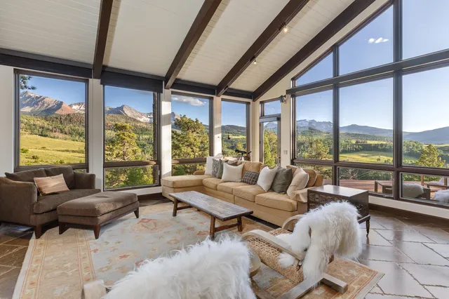 a living room with furniture and floor to ceiling windows