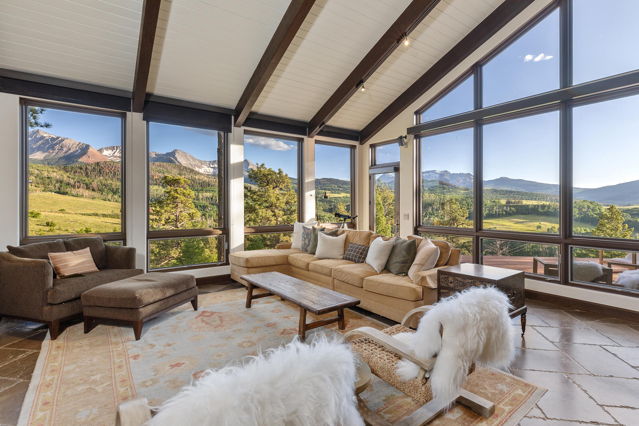 a living room with furniture and floor to ceiling windows
