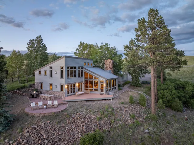 a front view of a house with a garden and trees