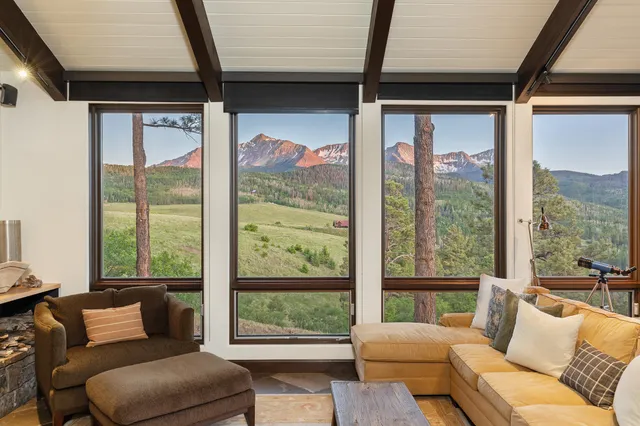 a living room with a large glass table and windows