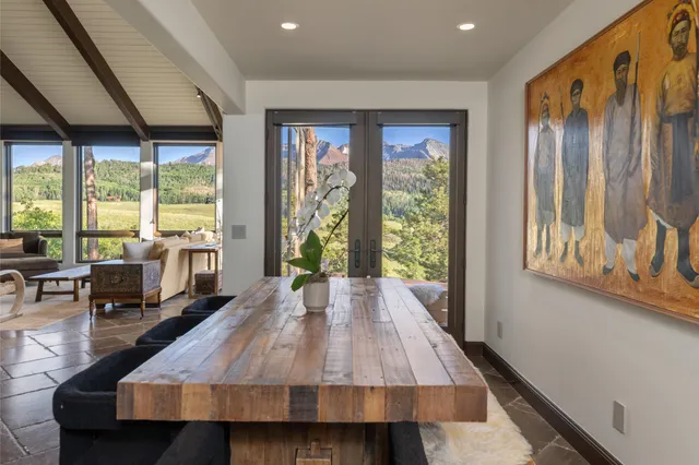 a dining area with furniture and a floor to ceiling window