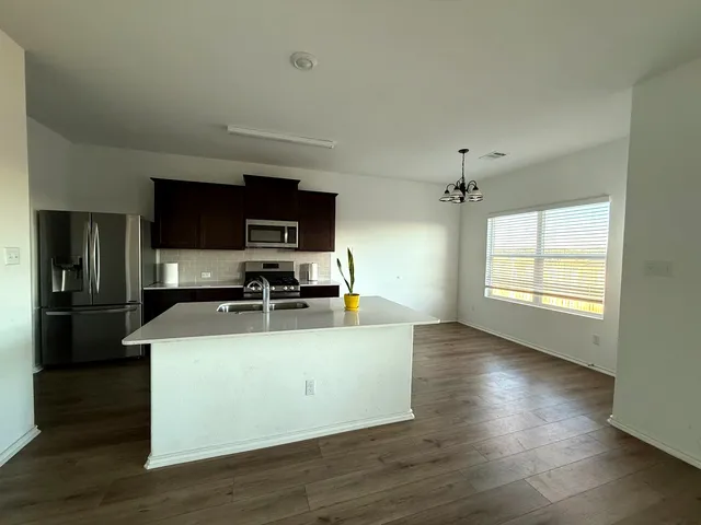 a kitchen with stainless steel appliances wooden floors and wooden cabinets