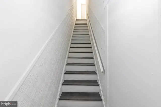 an empty room with wooden floor and mirror