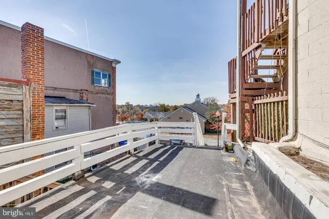 a view of a house with a barbeque and wooden floor