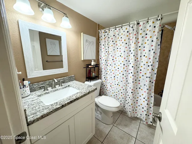 a spacious bedroom with a bed a couch and a chandelier