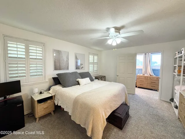 a spacious bedroom with two bed and a flat screen tv