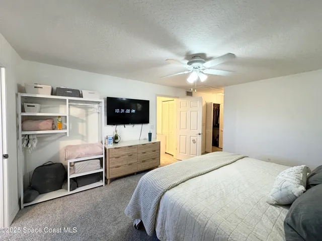 a spacious bedroom with a balcony a bed and a window