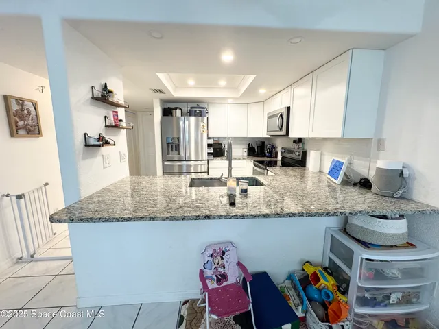 a kitchen with stainless steel appliances a refrigerator sink and microwave