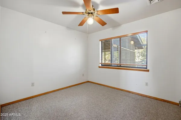 an empty room with a chandelier fan