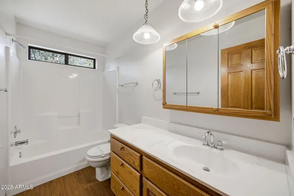 an empty room with ceiling fan and windows