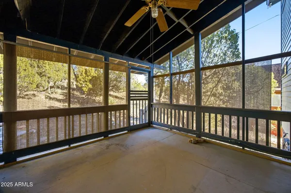 a view of a livingroom with a chandelier fan and windows