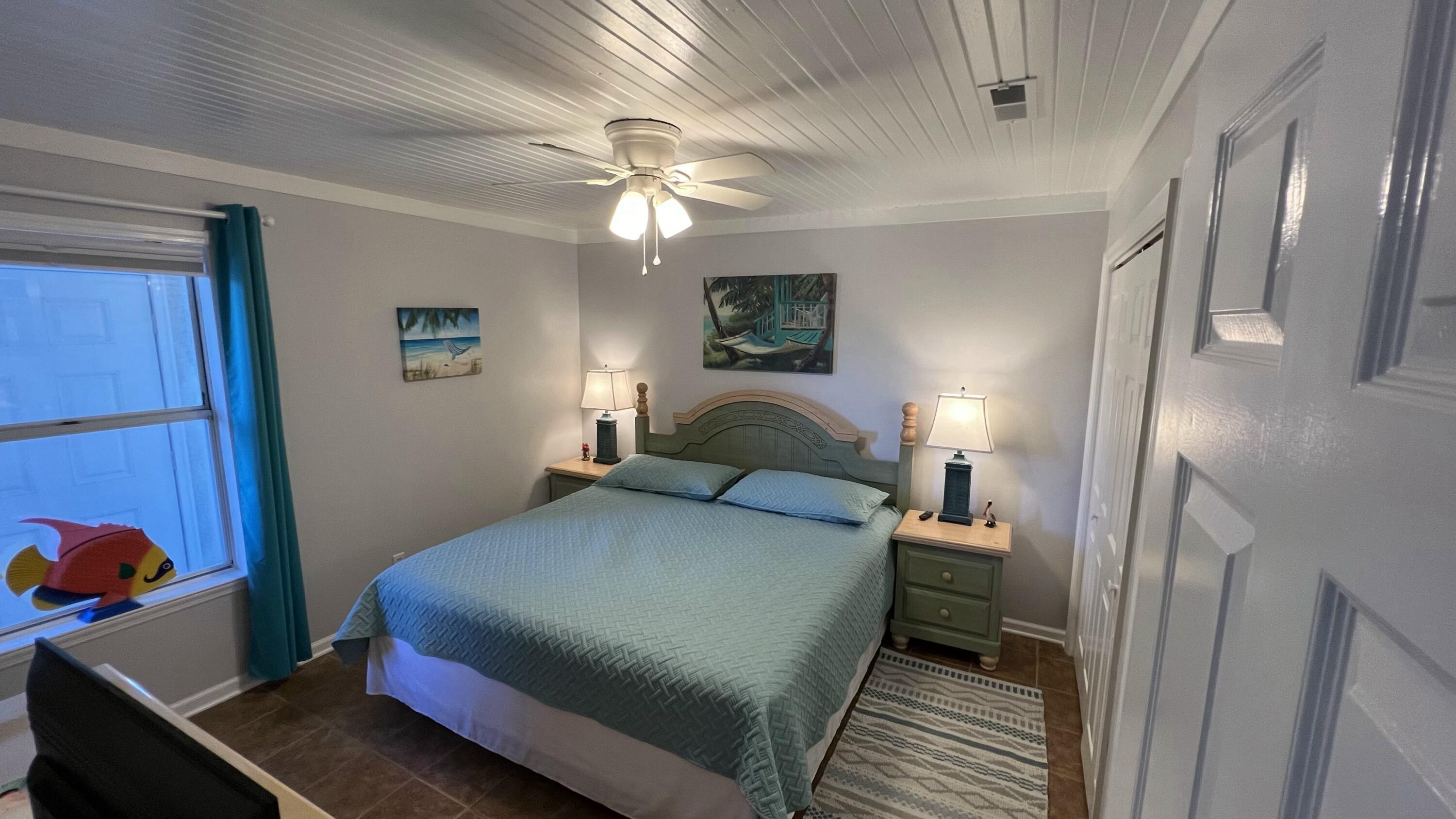 4984 West County Highway 30A, Unit 5B Santa Rosa Beach, FL 32459 - Photo 23 of 46 a bedroom with a bed and a chandelier