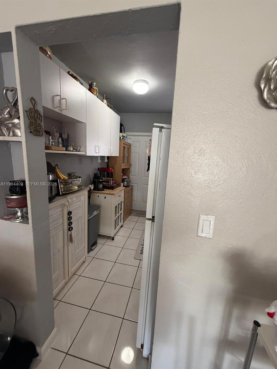3411 Southwest 11th Street, Unit 3B Miami, FL 33135 - Photo 6 of 14 a kitchen with a sink a refrigerator and cabinets