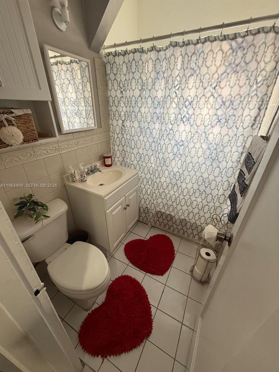3411 Southwest 11th Street, Unit 3B Miami, FL 33135 - Photo 10 of 14 a bathroom with a toilet sink and shower curtain