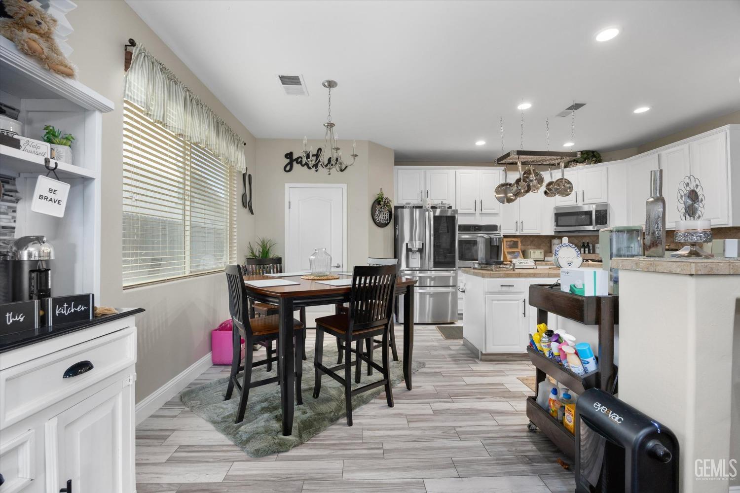 Undisclosed Address Bakersfield, CA 93312 - Photo 17 of 47 a kitchen with stainless steel appliances kitchen island granite countertop a table chairs and a refrigerator