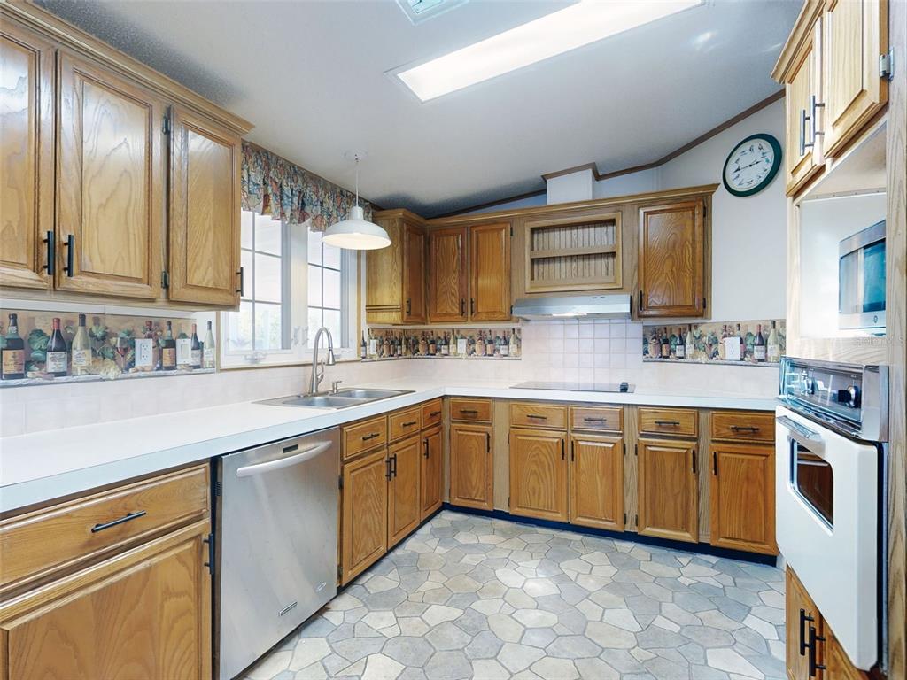 705 Starboard Avenue Edgewater, FL 32141 - Photo 14 of 52 a kitchen with stainless steel appliances granite countertop a sink and cabinets