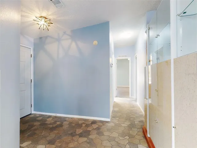 a view of a hallway with a chandelier fan