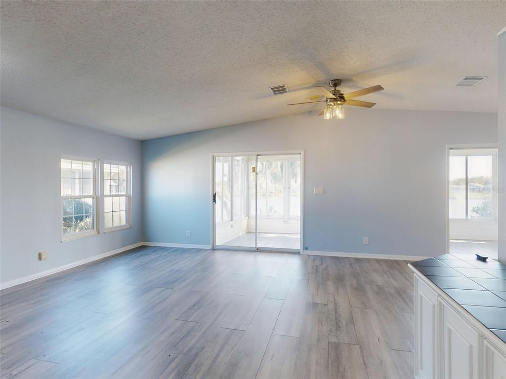 705 Starboard Avenue Edgewater, FL 32141 - Photo 4 of 52 an empty room with wooden floor fan and windows