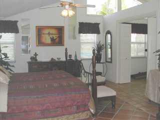 9345 Southeast Delafield Street Hobe Sound, FL 33455 - Photo 4 of 5 a living room with furniture and a chandelier