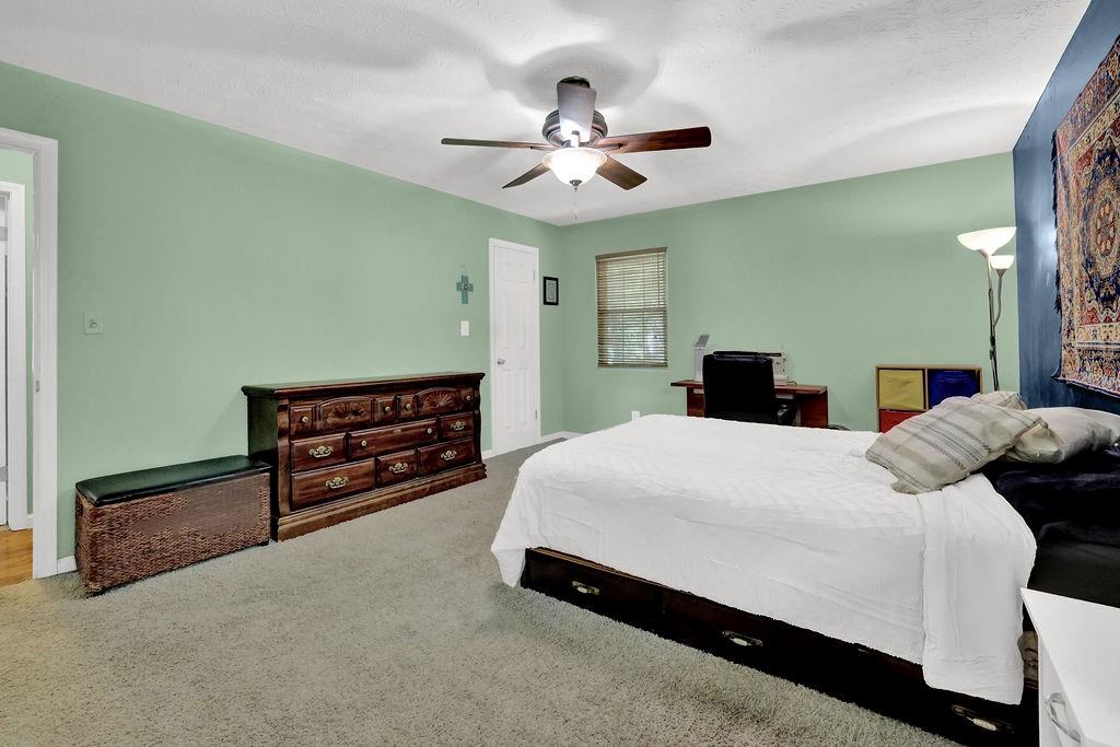 1555 Rock Springs Road Buford, GA 30519 - Photo 19 of 27 a bedroom with a bed and a chandelier