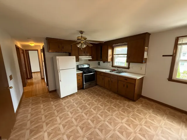 a kitchen with stainless steel appliances a stove a sink a refrigerator a window