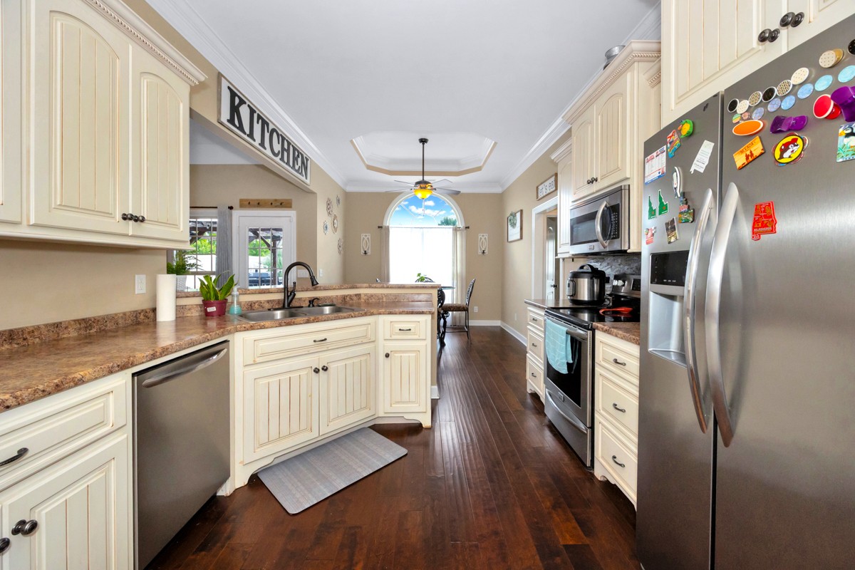 402 Vista Shores Road Rogersville, AL 35652 - Photo 20 of 55 a kitchen with granite countertop a refrigerator a sink dishwasher a dining table and chairs with wooden floor