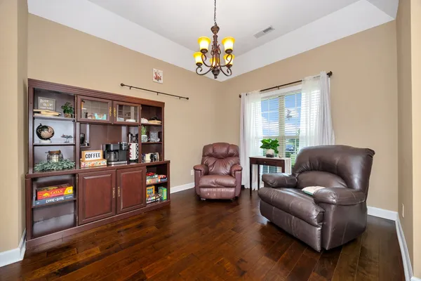 a living room with furniture and a chandelier
