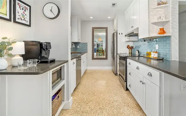 a kitchen with stainless steel appliances granite countertop a refrigerator and a stove