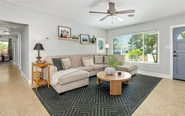 a living room with couches a coffee table and a chandelier with wooden floor