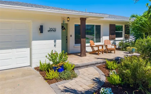 a view of a porch with chairs and potted plants