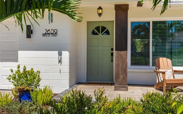 a vase of flowers sitting on a floor in front of a door